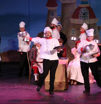 Chefs with platters dancing around a dinner table